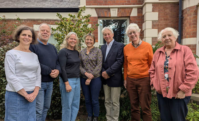 Six of the trustees posing along with artistic director John Moore