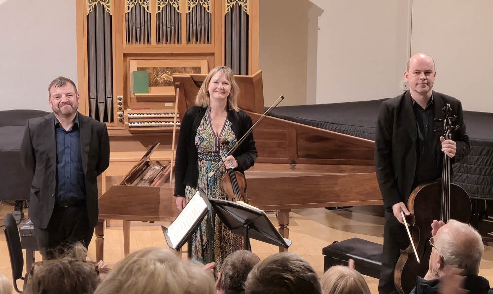 Steven Devine, Caroline Balding and Andrew Skidmore, standing and enjoy well-deserved applause