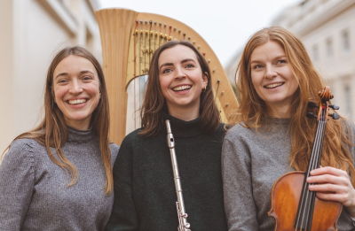 The three members of the Aglica Trio standing in front of Lise's Harp.